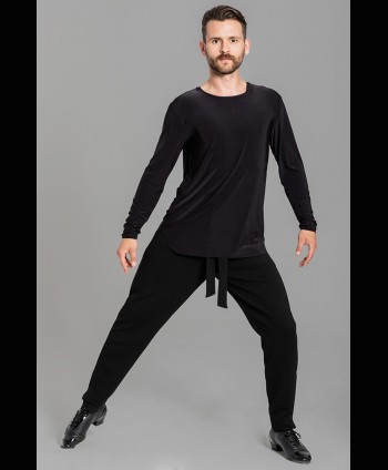 Tancerz ubrany w czarną taneczną bluzkę treningową, której materiał jest błyszczący oraz taneczne spodnie treningowe.